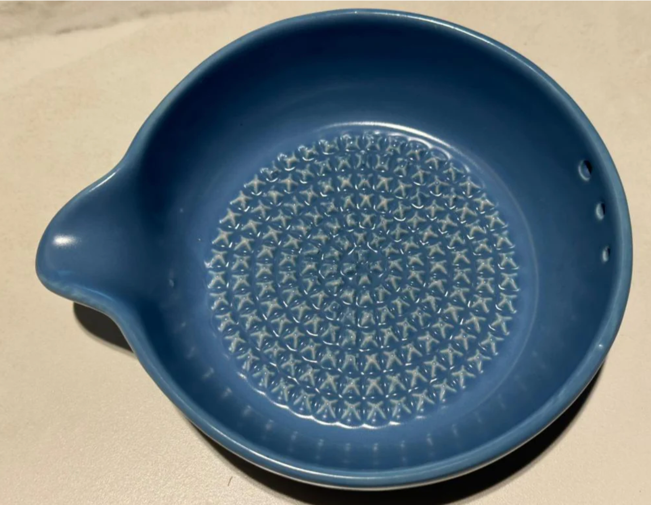 Blue ceramic dish with star pattern on a beige background