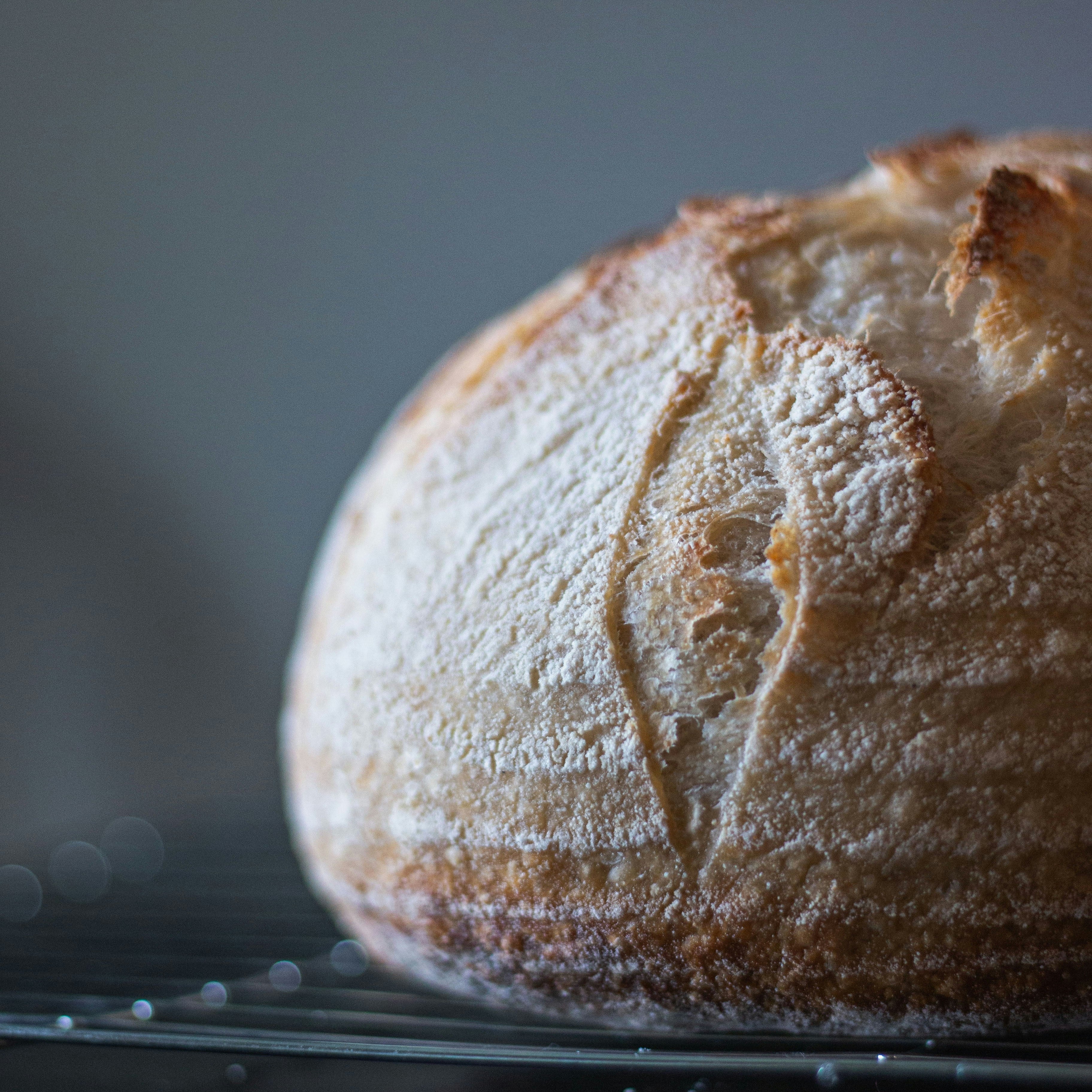 Loaf of bread on a cooling rack with a dark background